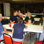 Family and friends gathered around a table sharing a meal and conversation.