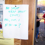 Handwritten event sign about a shoot on a wooden post.