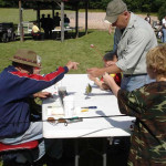 People gathered around a table outdoors, working on a project together.