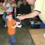 Young boy receives a trophy at a casual indoor event.