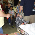 Children and adults gathered around a table, engaging in an activity.