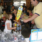 A child winning a large Minion toy at a carnival game.