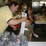 Man performing a science experiment with children watching.