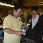 Two men examining a colorful magazine or brochure indoors.