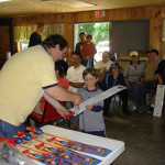 Man awards a young boy with a medal at a gathering.