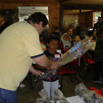 Man giving a wrapped gift to a child in a cozy room.