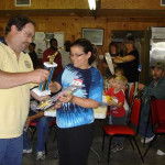 Woman receiving a trophy in a casual indoor gathering.