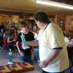 Two people exchanging items in a busy indoor setting.