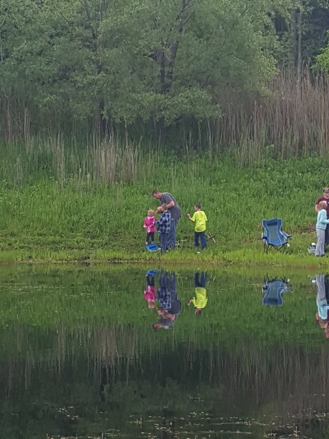 A group of people standing around by the water.