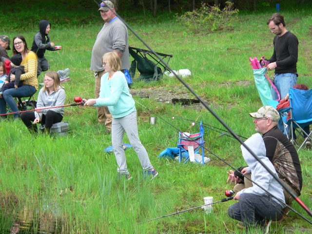 A group of people fishing in the grass.