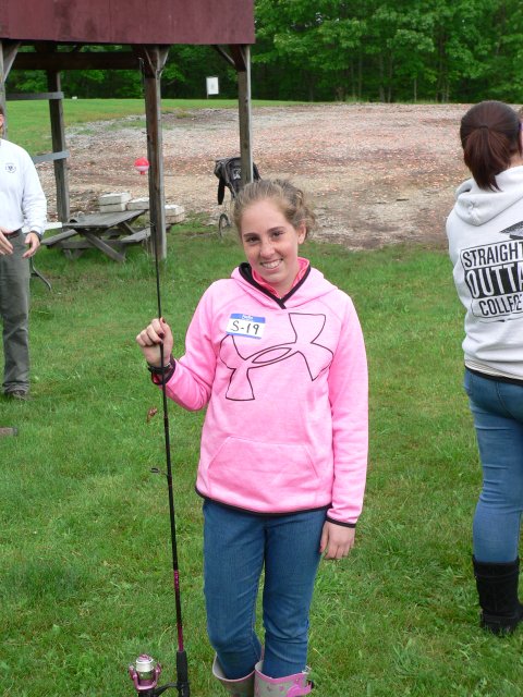 A girl in pink shirt holding up a stick.