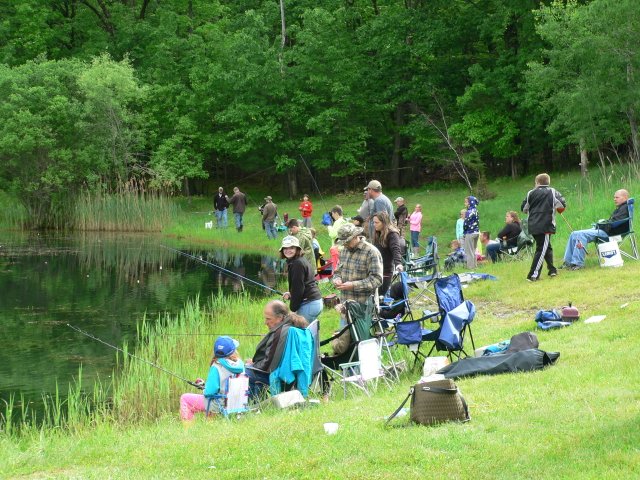A group of people fishing in the grass.