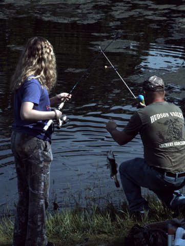 A man and woman fishing in the water.