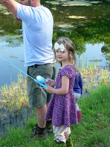 A man and little girl fishing in the water.