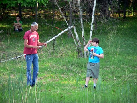 Two men in a field playing with a stick