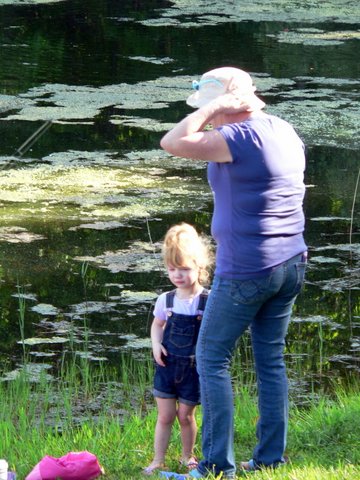 A woman and child standing in front of water lilies.