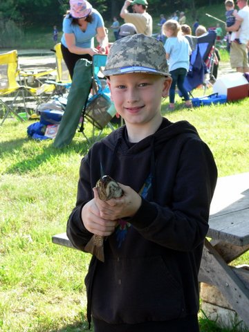A boy holding a snake in his hands.