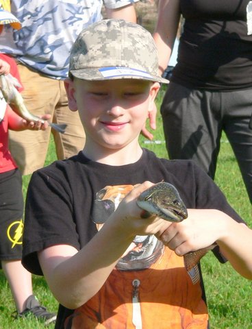 A boy holding a snake in his hand.