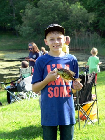 A boy holding a fish in his hands.