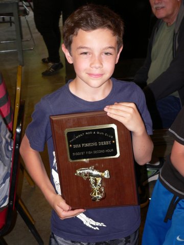 A young boy holding up a plaque with an airplane on it.