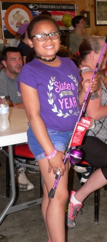 A girl in purple shirt holding onto a pole