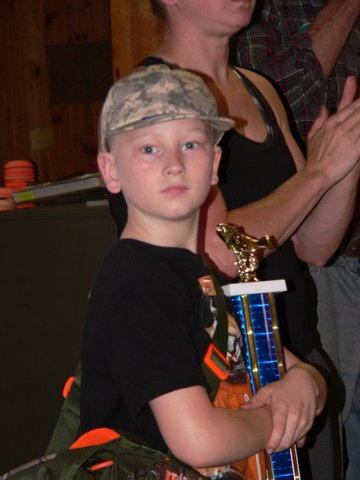 A young boy holding a trophy in his hands.