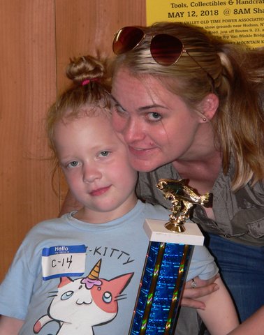 A woman and child holding a trophy