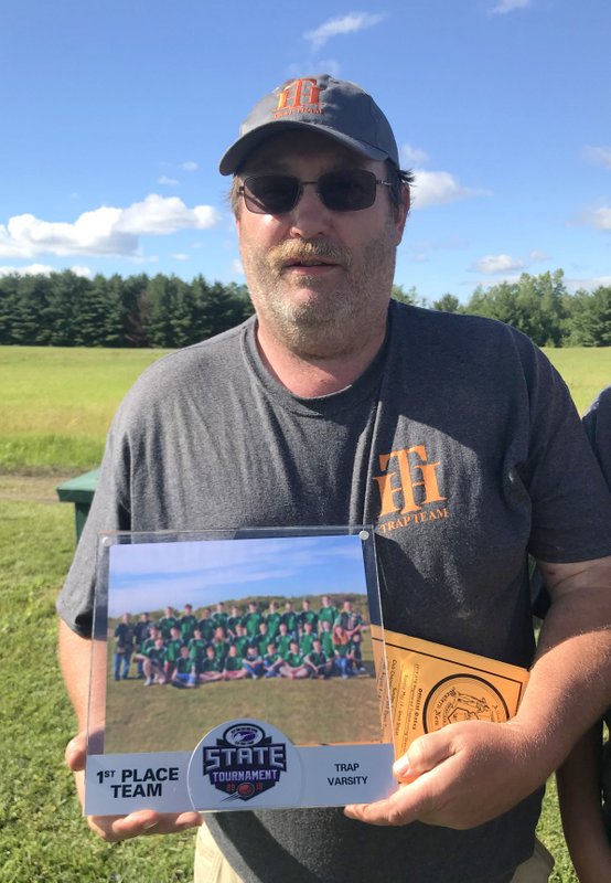 A man holding up a picture of a football team.